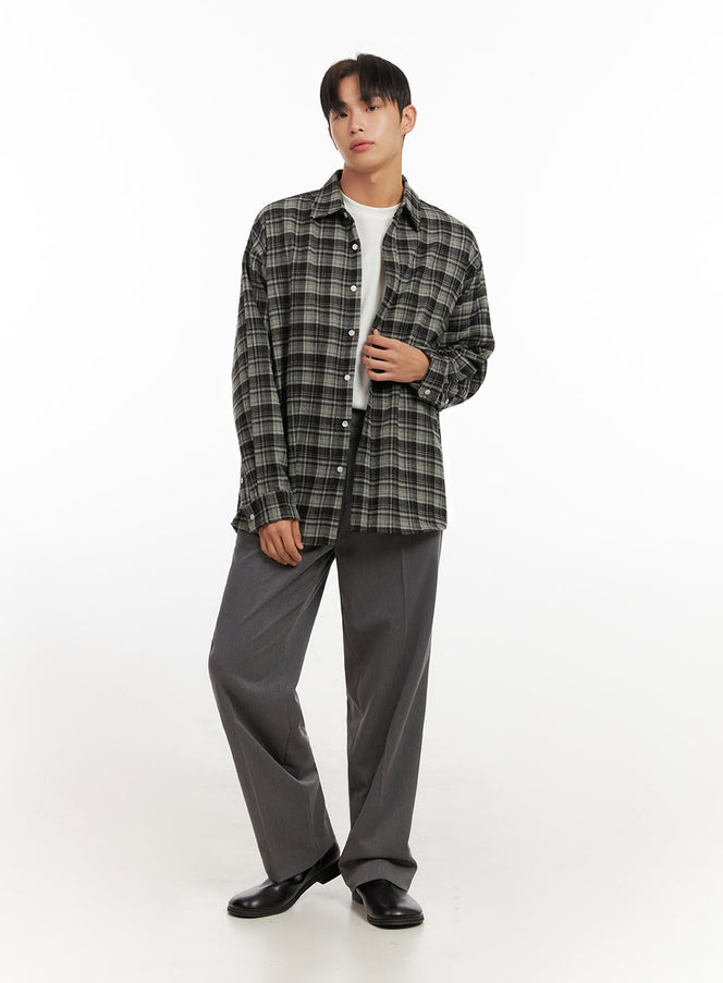 Men's Checkered Flannel ID406 in dark green, full-body front on model, open oversized flannel shirt, drop shoulder, paired with grey wide-leg trousers and black loafers.