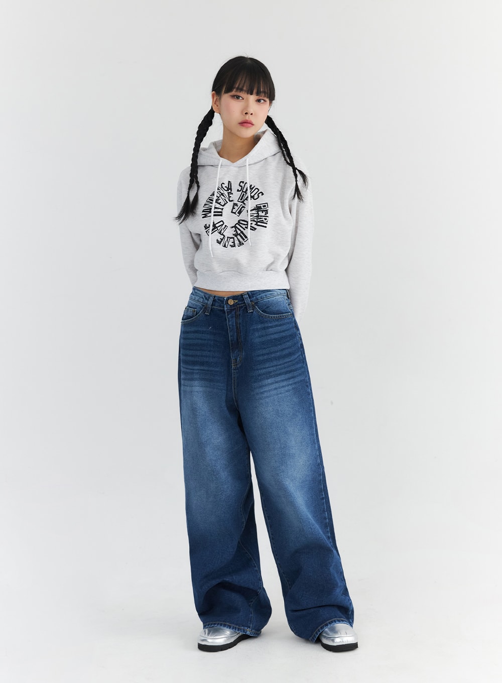 Washed Blue Wide Jeans CN301 in blue, front full-body on model, relaxed wide-leg silhouette with washed denim texture, paired with a grey graphic crop hoodie and silver shoes.
