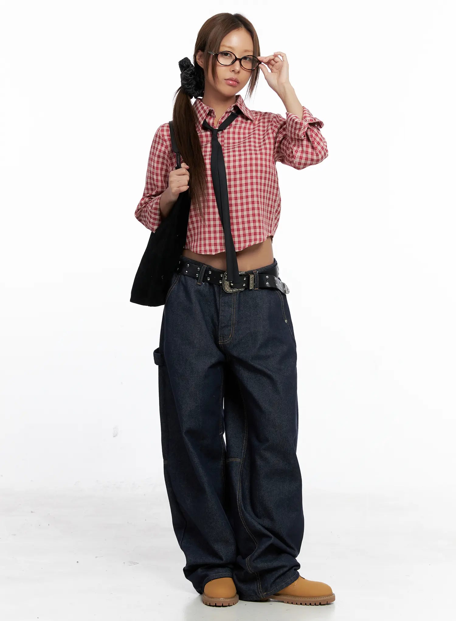 Relaxed Fit Dark Denim Jeans CS522 in dark blue, full-body front styling shot, model wearing red plaid crop shirt, black belt and tie, tote bag, tan boots, street acubi look.