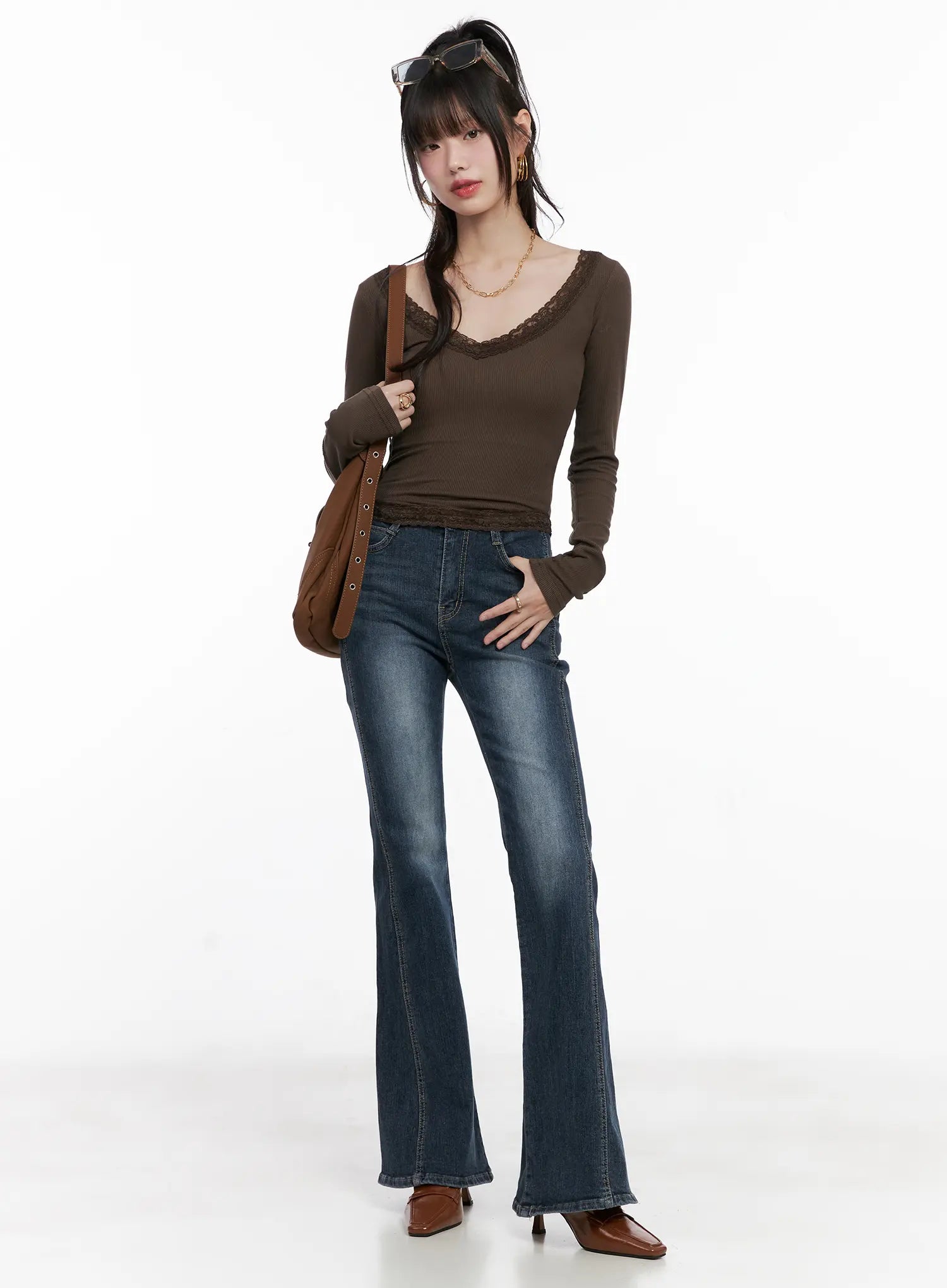 Giana High Waist Hip Pad Flare Jeans CG519 in blue, full-body front on model, styled with brown ribbed lace-trim top and brown shoulder bag, flare silhouette.