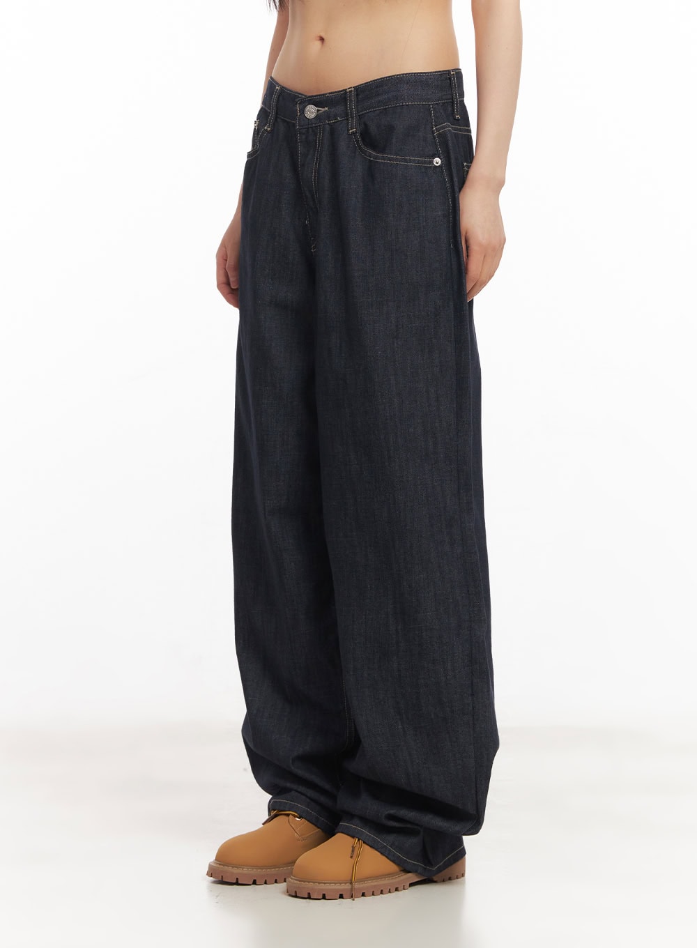 Ivara Wide-Leg Jeans CA522 in dark blue, side close-up on model, low-rise waistband with silver button, front pocket detail and contrast topstitching on wide-leg denim.