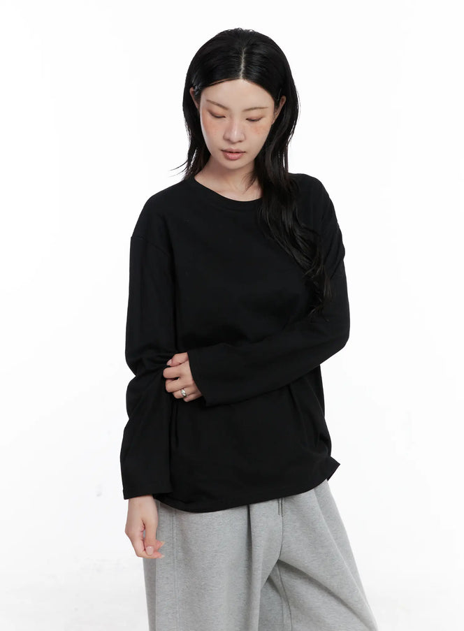Basic Oversized Long Sleeve Tee CS529 in black, cropped front close-up on model, drop shoulder cotton long sleeve with round neck, paired with grey sweatpants.