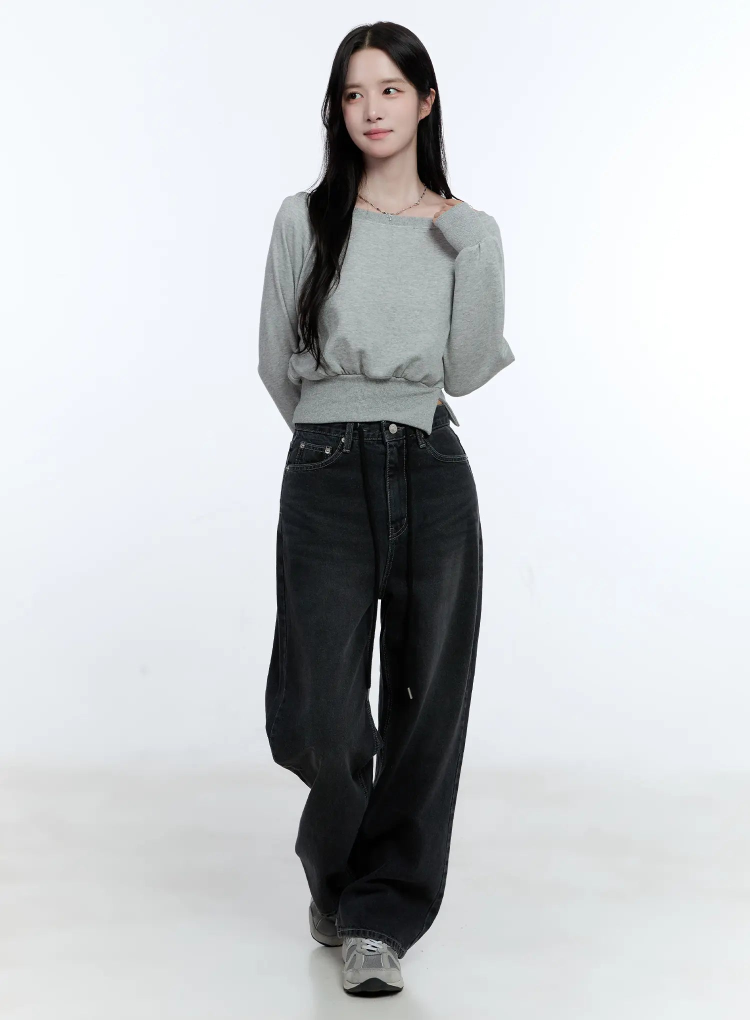 Lucinda High-Rise Wide Leg Jeans CG512 in black, full-body front shot on model standing straight, washed wide leg denim with drawstring, styled with gray off-shoulder top and chunky sneakers.