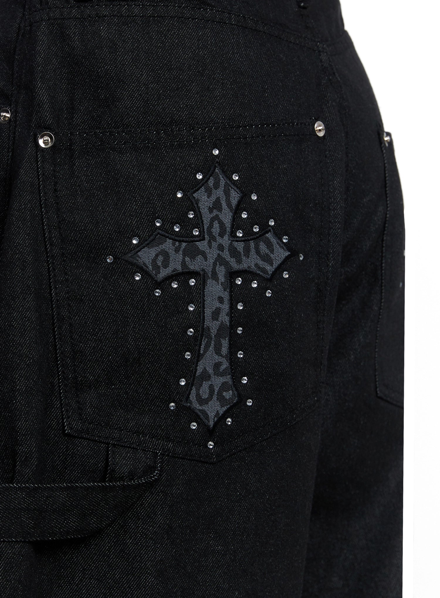 Lea Cross-Patch Baggy Jeans IS525 in black, macro close-up of back pocket, leopard-print cross patchwork surrounded by silver stud embellishments on dark cotton denim.
