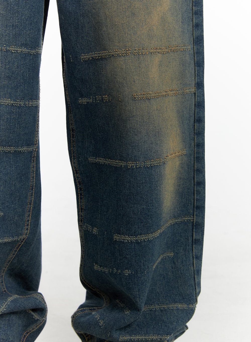 Scratch Textured Baggy Jeans CM405 in washed indigo blue, close-up detail of leg panel, showing horizontal destroyed scratch stitching lines and vintage yellow fading across wide-fit denim fabric.