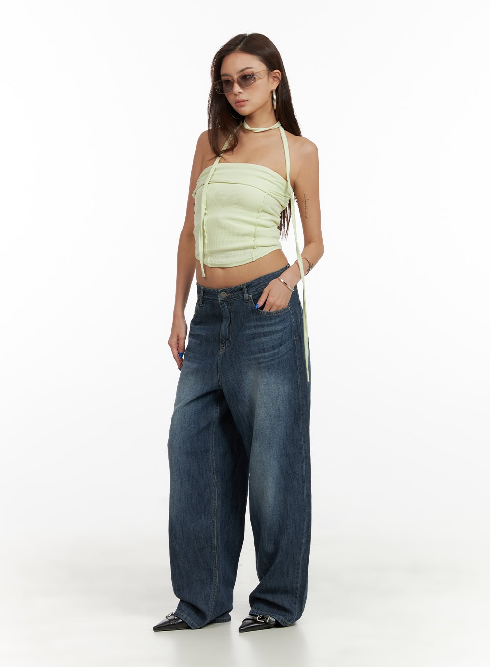 Low Rise Wide Fit Baggy Jeans CY431 in dark blue, full-body 3/4 front angle on model, low waist washed denim with wide floor-length leg, paired with lime green ruched halter top and black flats.