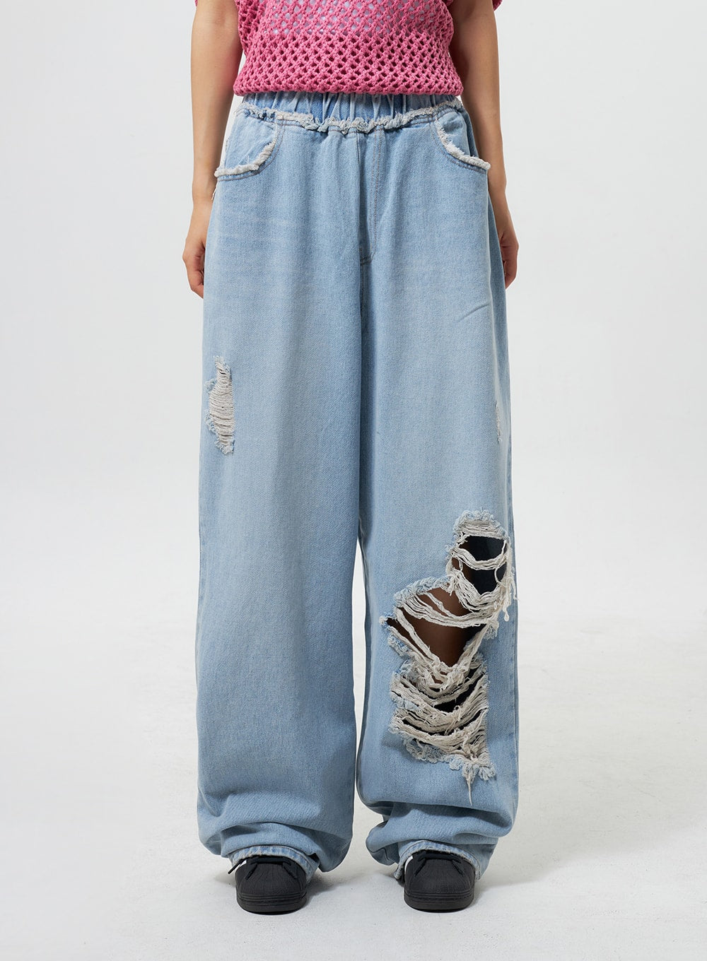 Oversized Ripped Jeans CY324 in light blue, front mid-shot on model, showcasing large destroyed rips and frayed threads on wide-leg denim with elastic banded waistband.
