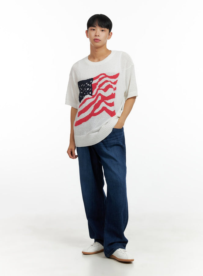 Men's Washed Cotton Denim Jeans CL429 in dark blue, full-body front on male model, relaxed wide-leg fit, styled with white American flag knit top and white sneakers.