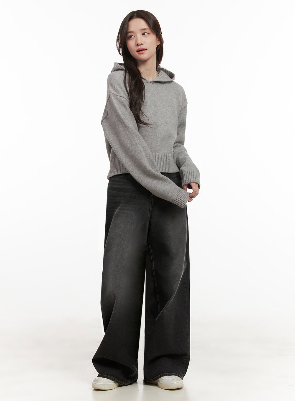 Christina Washed Baggy Jeans IJ510 in black, full-body side-angled shot on model, ultra-wide baggy leg silhouette styled with a grey knit hoodie and white sneakers.