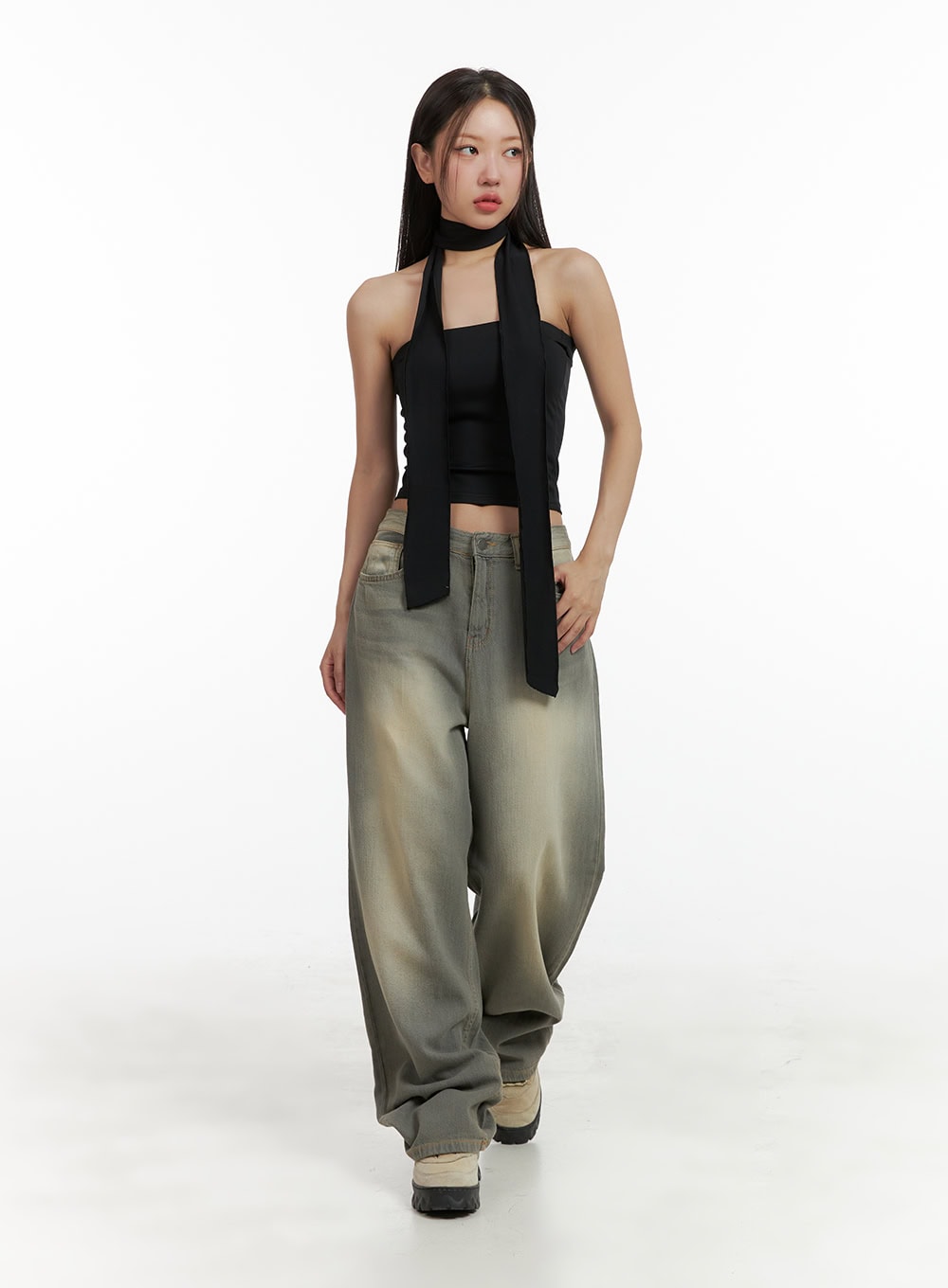 Washed Baggy Denim Jeans CU404 in Brown, full-body front shot on model walking, oversized wide-leg silhouette, styled with black halter crop top and chunky sneakers.