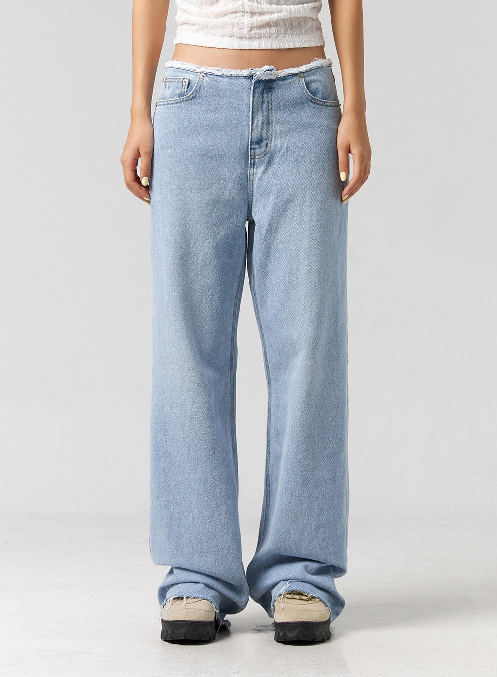 Cut Waist Wide Leg Jeans CG323 in light blue, front waist-to-hem close-up on model, frayed raw-edge waist, five-pocket styling, relaxed wide leg pooling at raw-hem ankles.