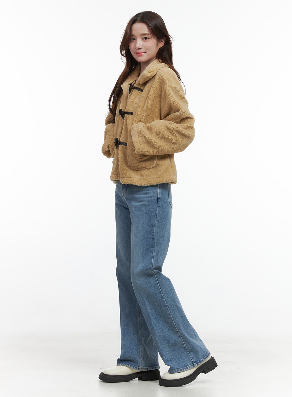 Aubrey Washed Classic Straight-Fit Jeans OO421 in blue, 3/4 side view on model, wide straight-leg washed denim, styled with a camel sherpa toggle jacket and chunky white loafers, casual preppy look.