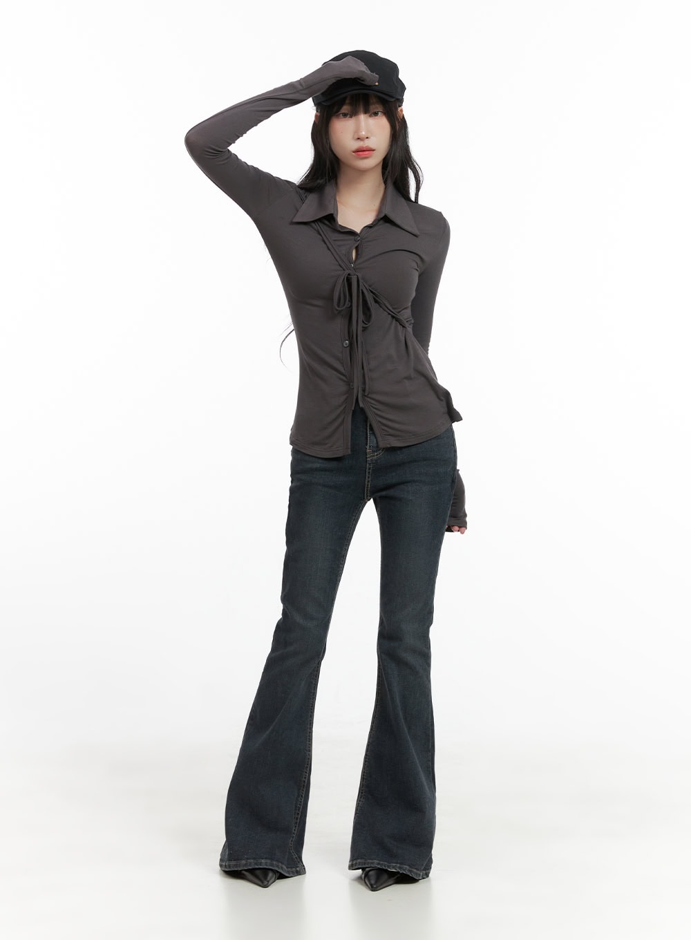 Zadie Slim Washed Denim Bootcut Jeans CG421 in dark blue, full-body front shot on model wearing black baker boy cap and grey tie-front top, slim high-waist silhouette with dramatic bootcut flare.