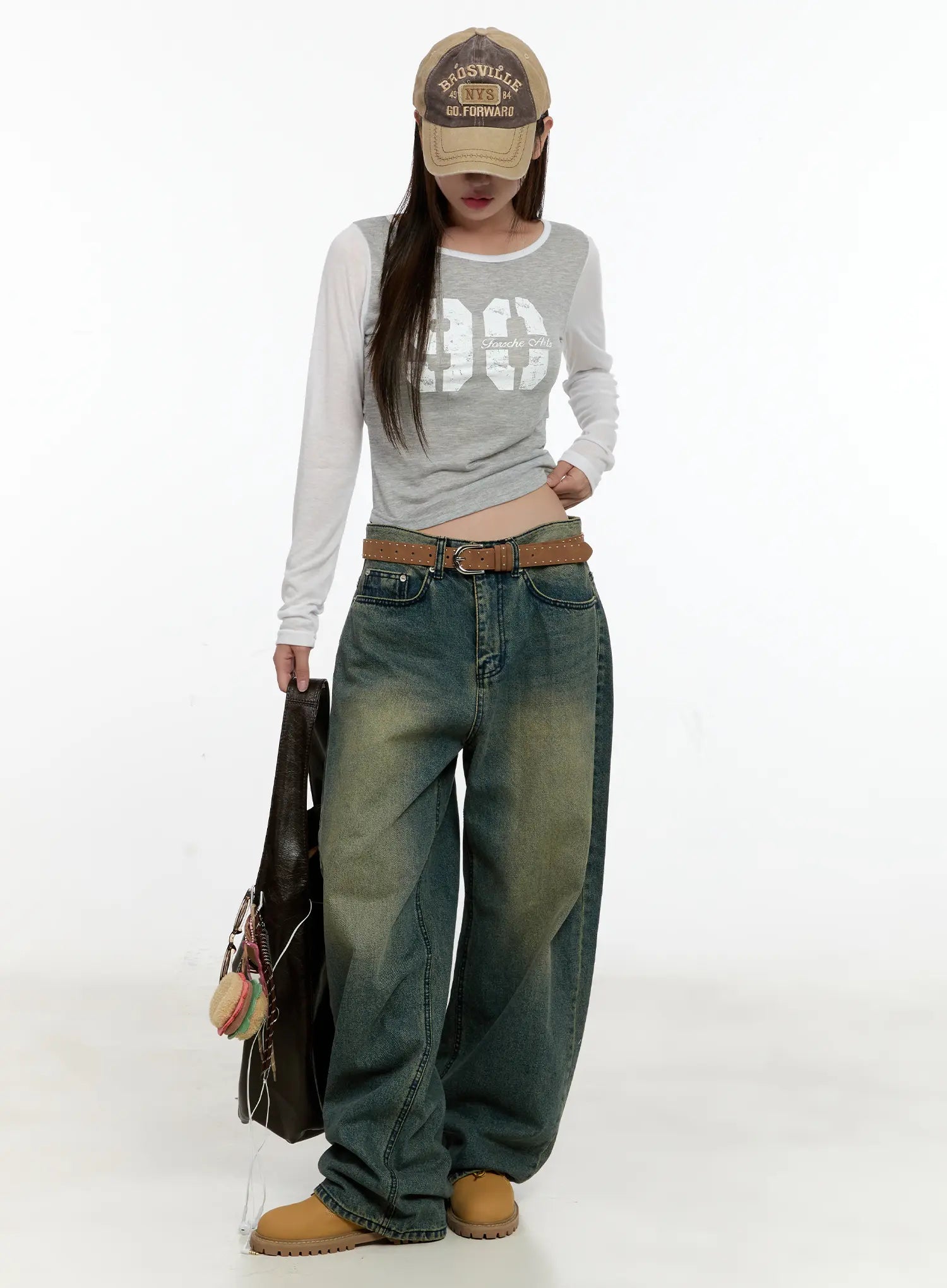 Sooyoung Baggy Vintage Wash Jeans CL531 in dark blue, full-body front on model with cap and leather tote, wide-leg vintage wash denim belted with a graphic crop top.