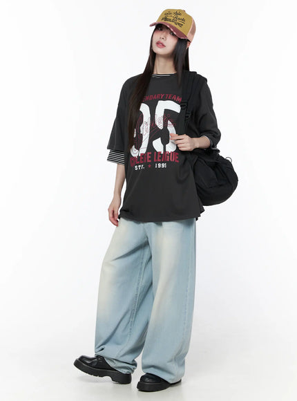 Ozzy Washed Wide Leg Jeans CU519 in light blue, full-body styling shot, model in graphic tee and trucker cap with shoulder bag, oversized street look.