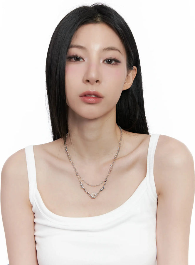 Donut Pendant Necklace CO503 in silver, full front view on model, layered chain necklace with wavy charm details, styled with white ribbed tank top.