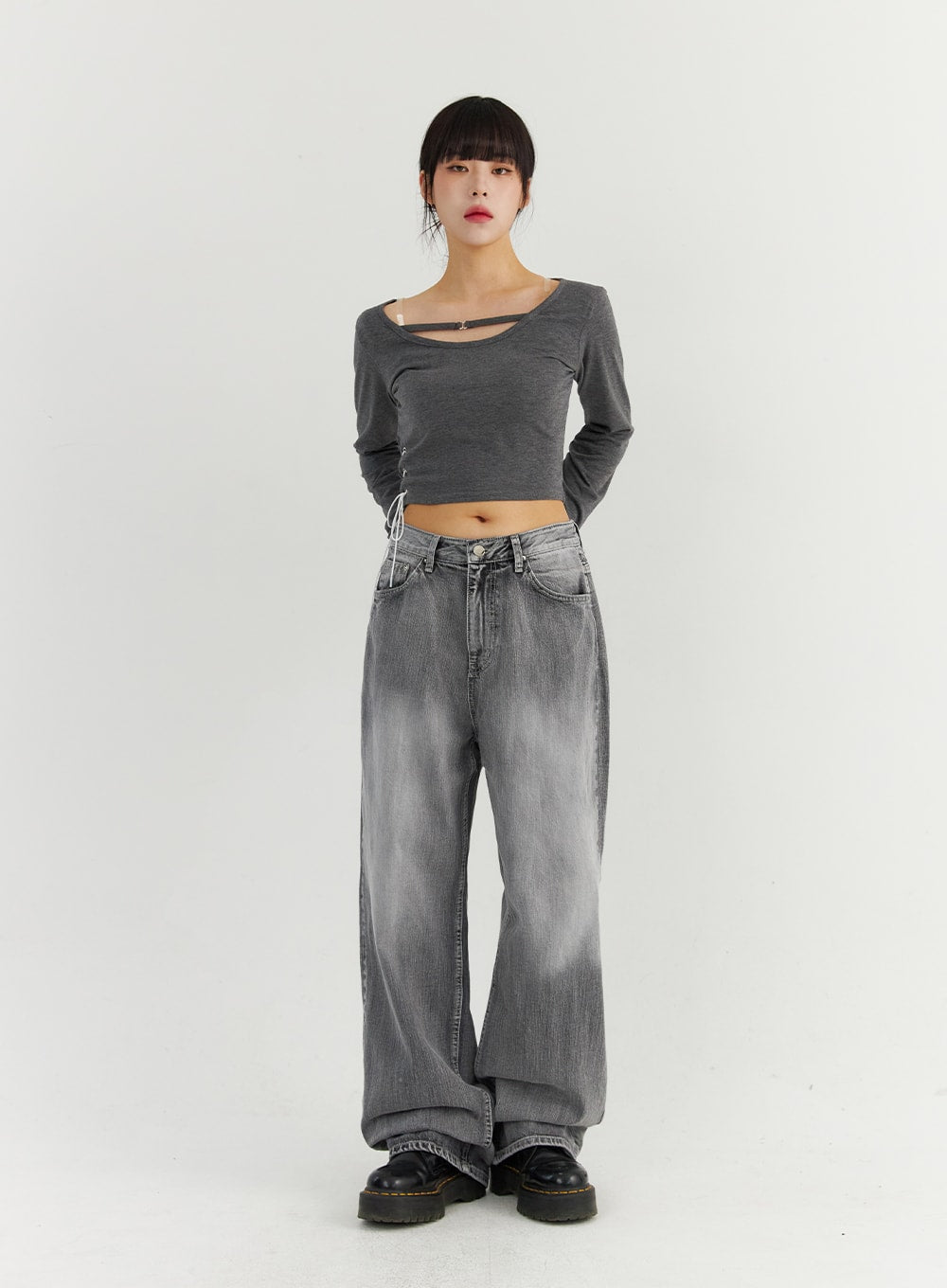 Grey Washed Wide Leg Jeans CO323 in Gray, full-body front view on model standing straight, floor-grazing wide-leg silhouette with washed fading, styled with gray cut-out crop top and platform boots.