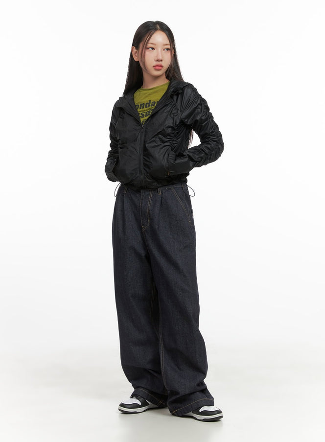 Shirred Hooded Nylon Crop Jacket CO402 in black, full-body front view on model, zip-up crop silhouette with all-over shirring, styled with olive tee, dark baggy jeans, and black-white sneakers.