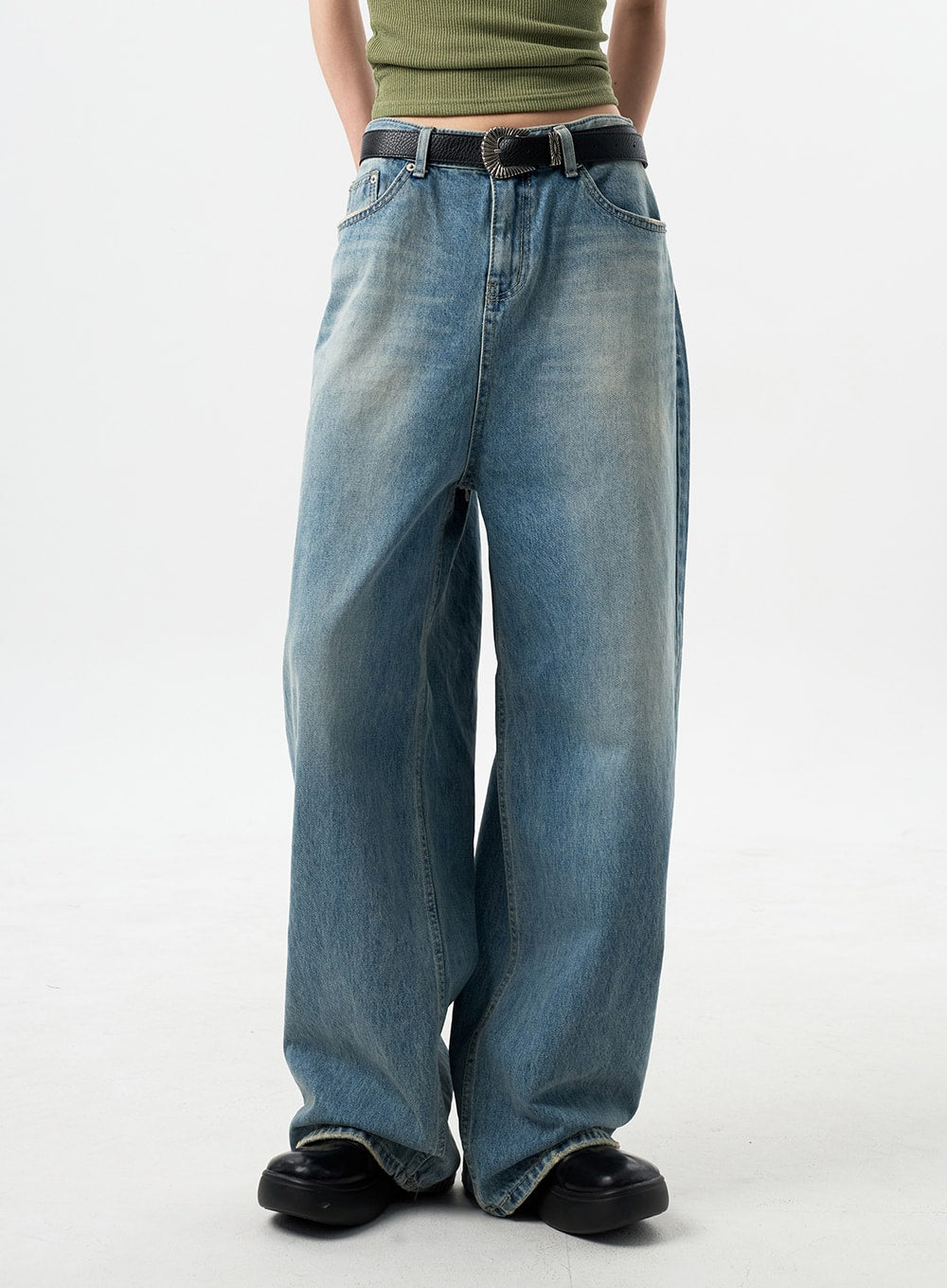 Oversized Jeans Unisex CY312 in washed blue, front waist-to-hem close-up on model, wide-leg silhouette with vintage fading and black western belt detail.