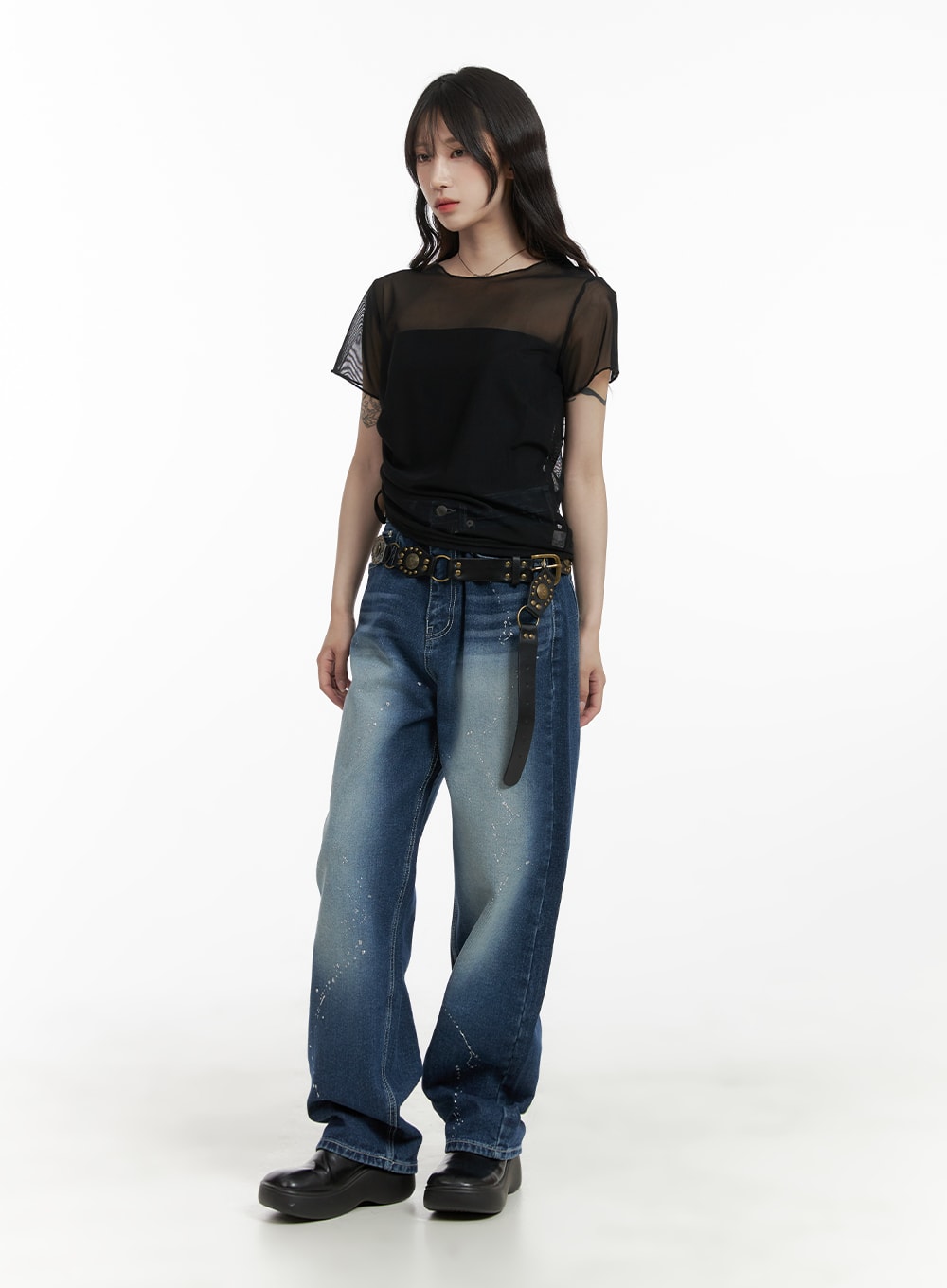 Splash Paint Baggy Jeans CA408 in blue, full-body front shot on model, baggy wide-leg washed denim with paint splatter, paired with sheer black mesh tee and studded belt.