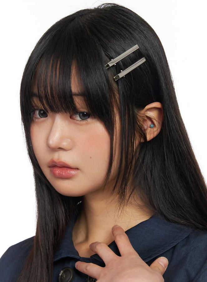 Sleek Hair Clip CF506 in silver, front portrait on model, two bar clips pinned to side part of straight black hair, paired with navy double-breasted jacket.