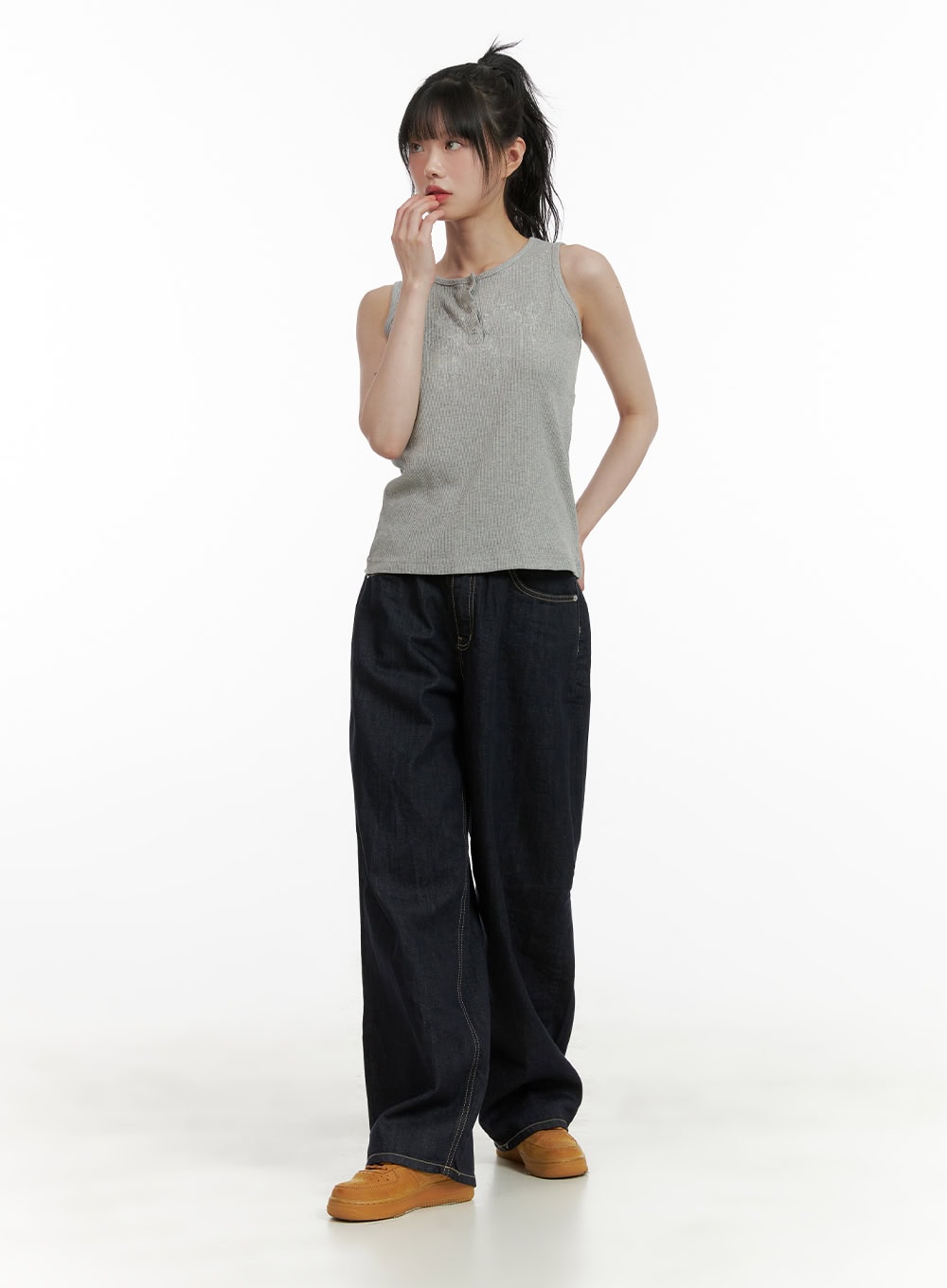 Stitch Detail Baggy Jeans CU410 in dark blue, full-body shot on model, wide-leg silhouette with contrast stitching, styled with grey ribbed tank top and tan sneakers, casual street look.