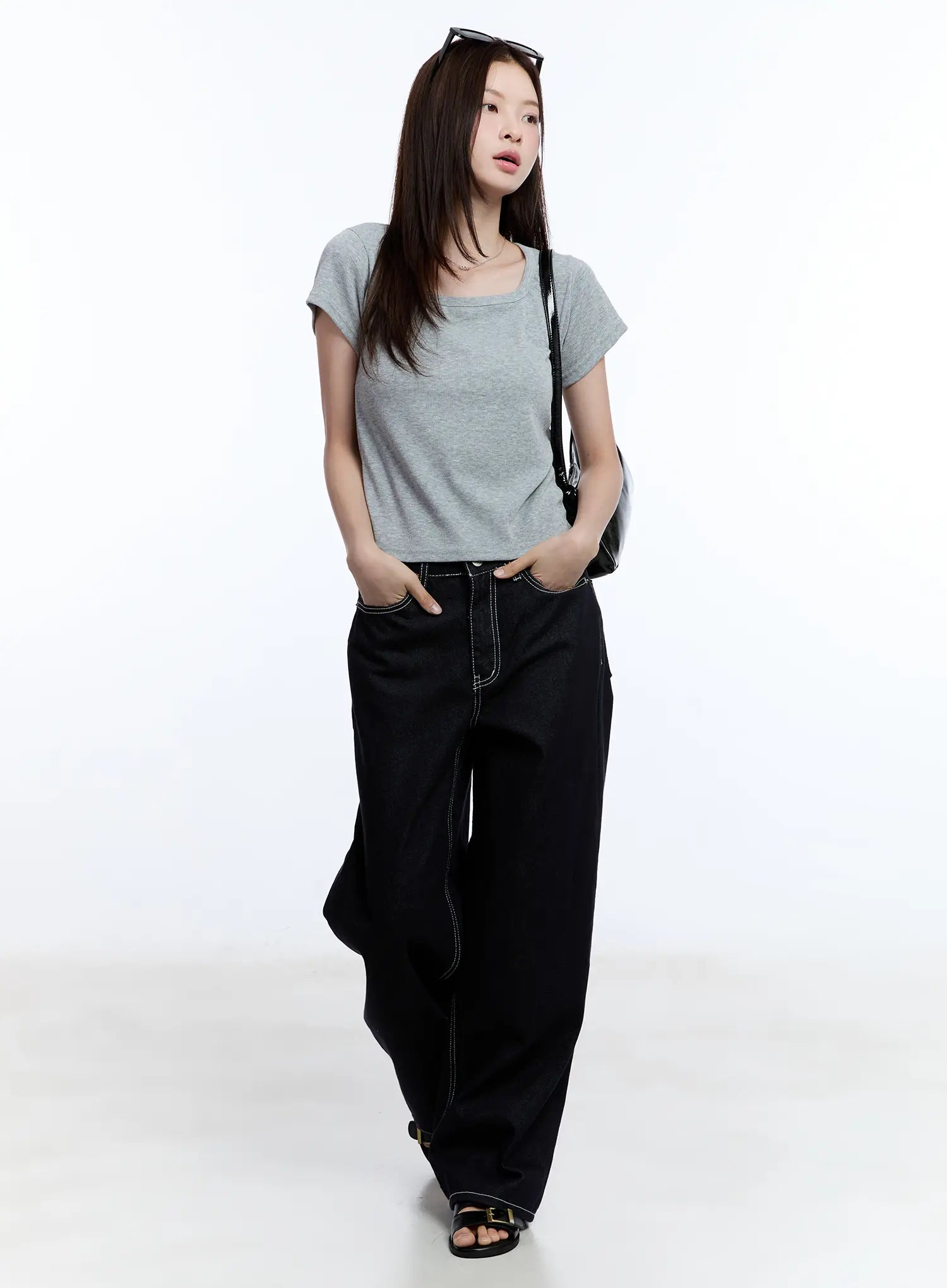 Nayeon No-Fade Denim Jeans CU513 in dark blue, full-body editorial shot on model walking, wide-leg silhouette styled with grey scoop-neck tee, crossbody bag, and black sandals.