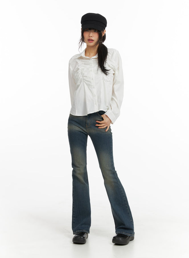 Washed Flared Jeans CM413 in blue, full-length front view on model wearing black cap and white ruffled shirt, slim bootcut silhouette with washed finish.