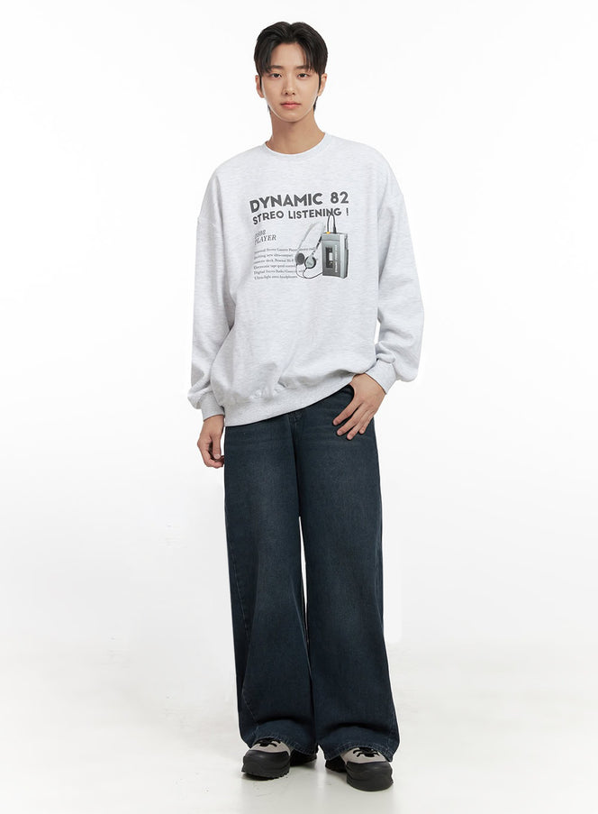Men's Graphic Cotton Sweatshirt ID406 in white, full-body front shot on model, Dynamic 82 Stereo Listening graphic, oversize drop-shoulder fit, ribbed hem, styled with dark wide-leg jeans and sneakers.