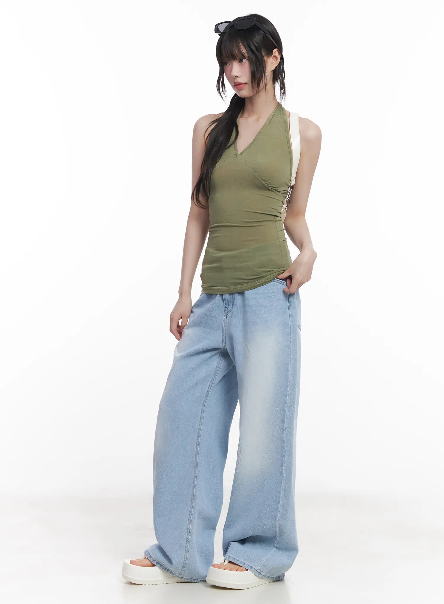 Haerin Washed Wide-Leg Jeans CU519 in light blue, full-body front shot on model, relaxed wide-leg silhouette, styled with olive green halter top and white mini bag.