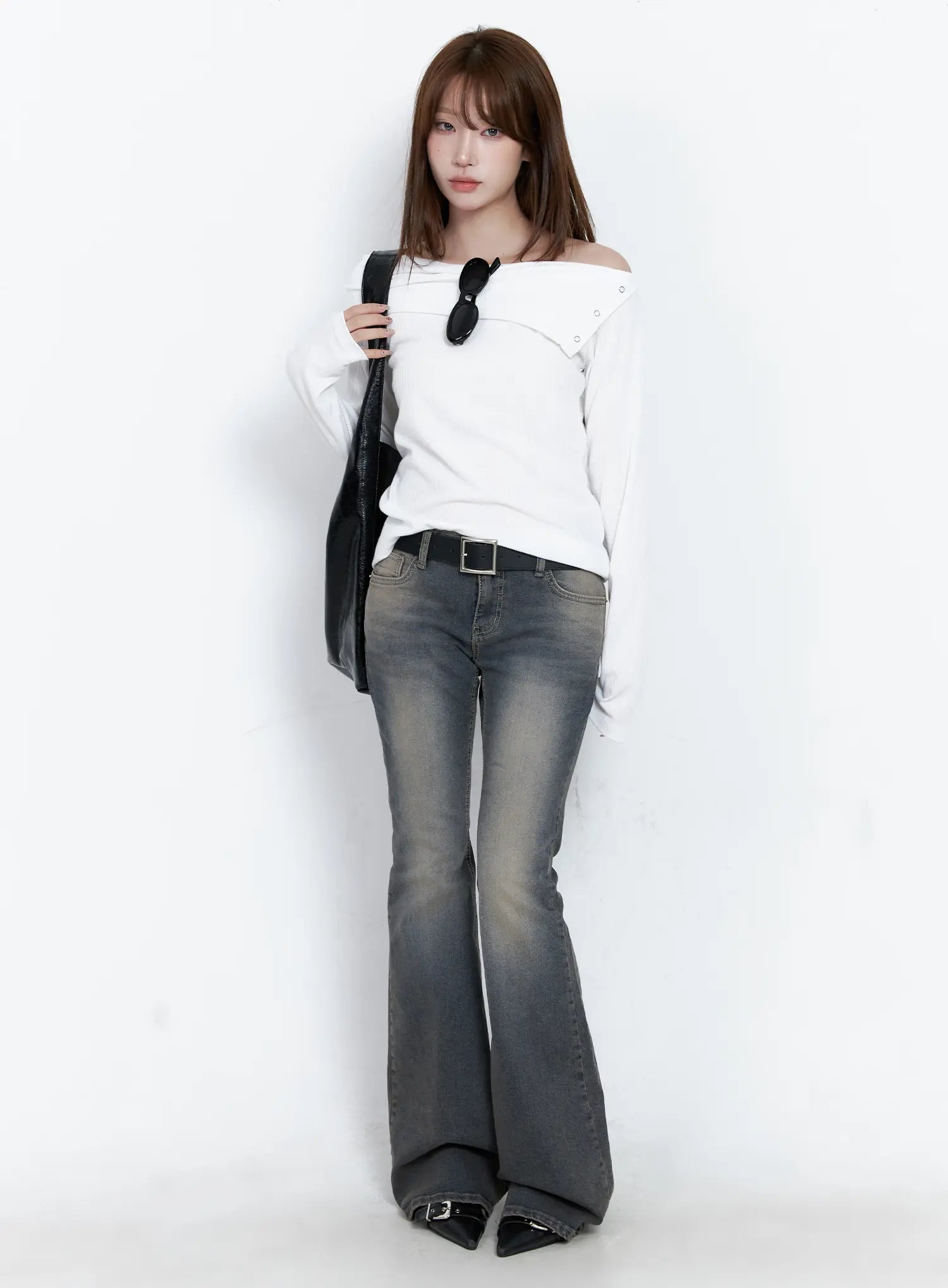 Sumin Low-Rise Flare Hip Pad Jeans CG529 in gray, full-body front shot on model, styled with white off-shoulder top, black belt, and black tote bag.