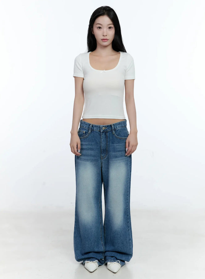 Ribbed U-Neck Crop Tee CL530 in white, full-body front shot on model, slim-fit short-sleeve crop top showing midriff, styled with wide-leg faded blue jeans and white sneakers.
