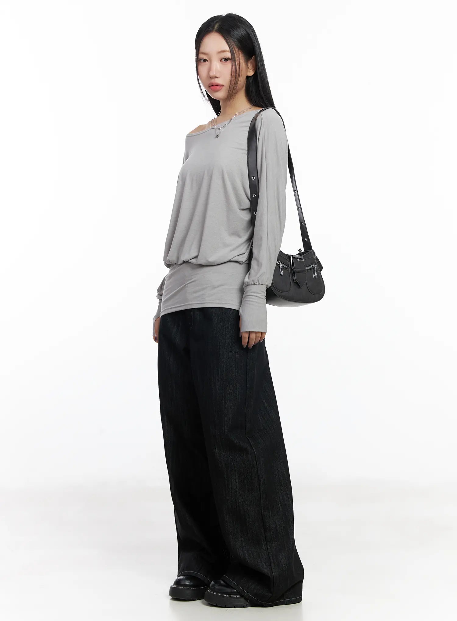 Violet Studded Baggy Jeans CJ530 in black, 3/4 side view on model styled with grey off-shoulder top and black shoulder bag, floor-length wide-leg silhouette, black loafers.