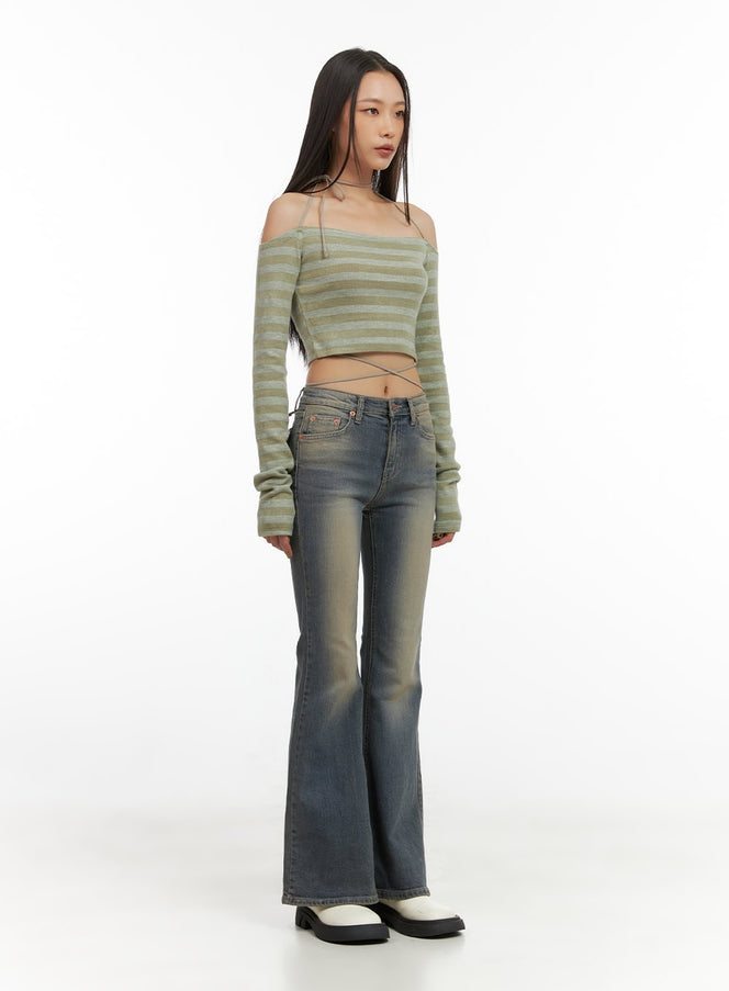Lydia Slim Washed Bootcut Jeans CO424 in Blue, full-body 3/4 angle on model, slim washed denim bootcut silhouette styled with green off-shoulder striped crop knit.