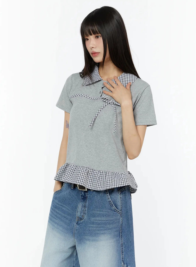 Frill Trim Collar Top CU515 in grey, three-quarter front shot on model, gingham collar and ribbon bow detail, frill trim hem, paired with blue wide-leg jeans.
