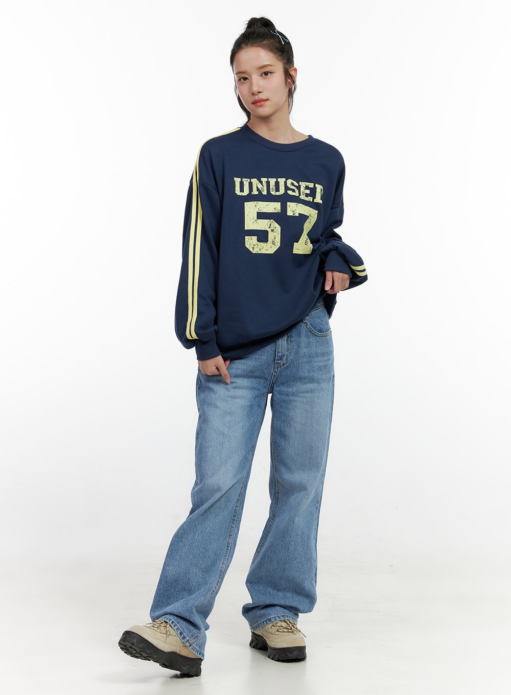 Carly Cloud Wide-Leg Jeans ON404 in blue, full-body front on model, relaxed wide-leg washed denim pooling at hem, styled with navy varsity sweatshirt and chunky sneakers.