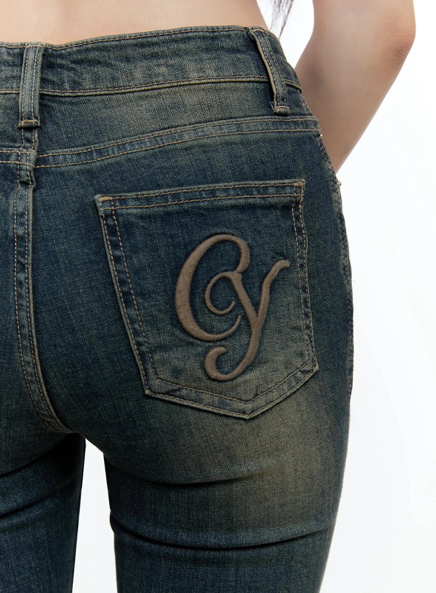Karla Vintage Logo Hip Pad Flare Jeans IO520 in washed dark blue, close-up of back pocket with raised CY logo embroidery, vintage wash texture and contrast stitching visible.