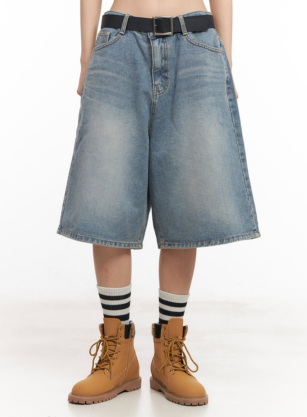Washed Baggy Jorts IY529 in light blue, front close-up on model, wide-leg midi denim with washed fading, black belt at waist, paired with striped socks and tan lace-up boots.