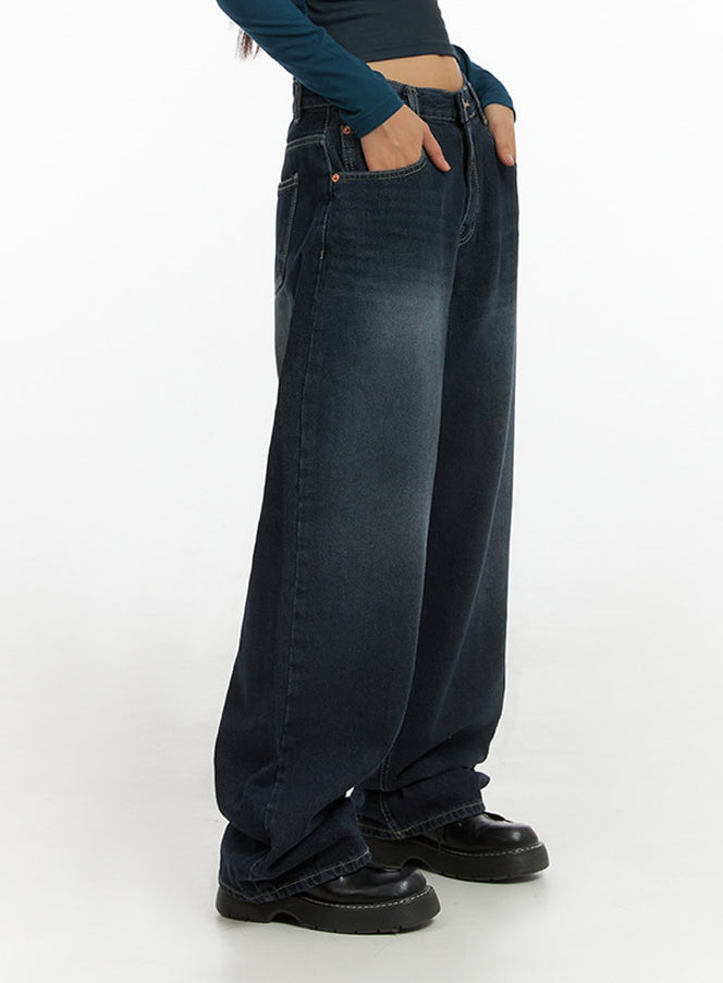 Evelyn Washed Baggy Jeans (Dark Blue) IS402 in dark blue, side close-up waist-to-floor on model, hand in pocket, wide-leg washed denim with contrast stitching, worn with black chunky loafers.