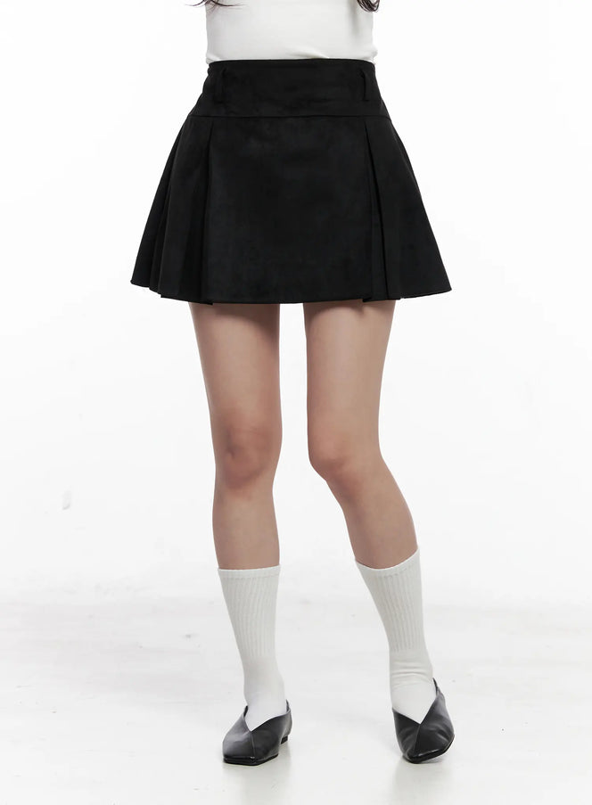 Chic Pleated Mini Skirt CO524 in black, front close-up on model from waist to ankles, banded high waist, flare pleats visible, paired with white top, white socks, black flats.
