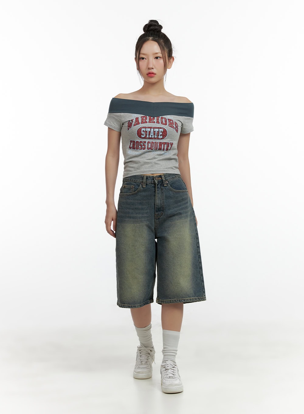 Slim Fit Bermuda Jorts CL410 in blue, full-body front shot on model, wide-leg washed denim jorts styled with a grey graphic off-shoulder top and white sneakers.