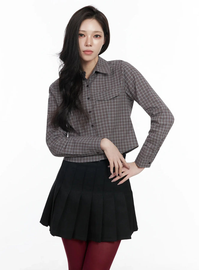 Checkered Crop Shirt IJ528 in dark brown, front full-body shot on model, slim-fit cropped cotton check shirt with collar and chest pocket, paired with black pleated skirt and burgundy tights.