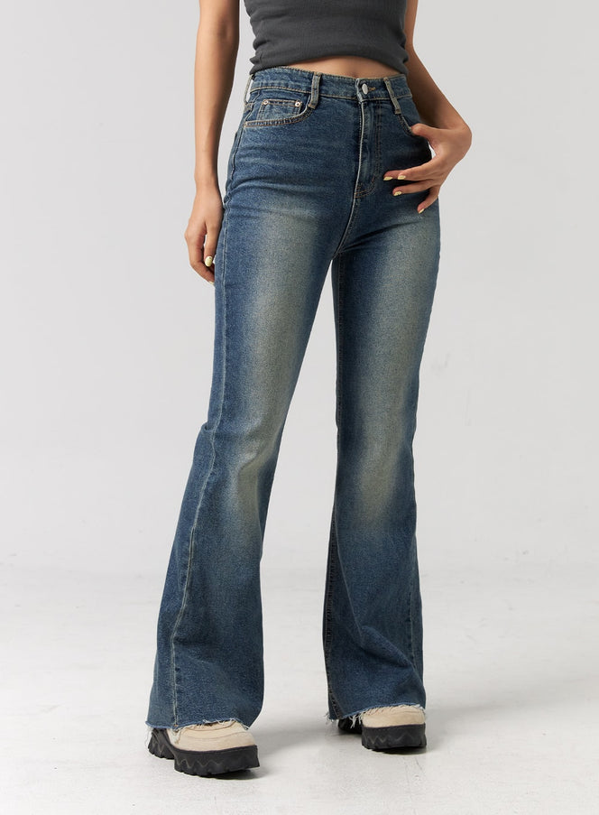 Slim Fit Bootcut Jeans CG319 in blue, front close-up on model from waist to ankle, high-rise slim fit, faded wash, visible coin pocket and zip fly, raw frayed hem.