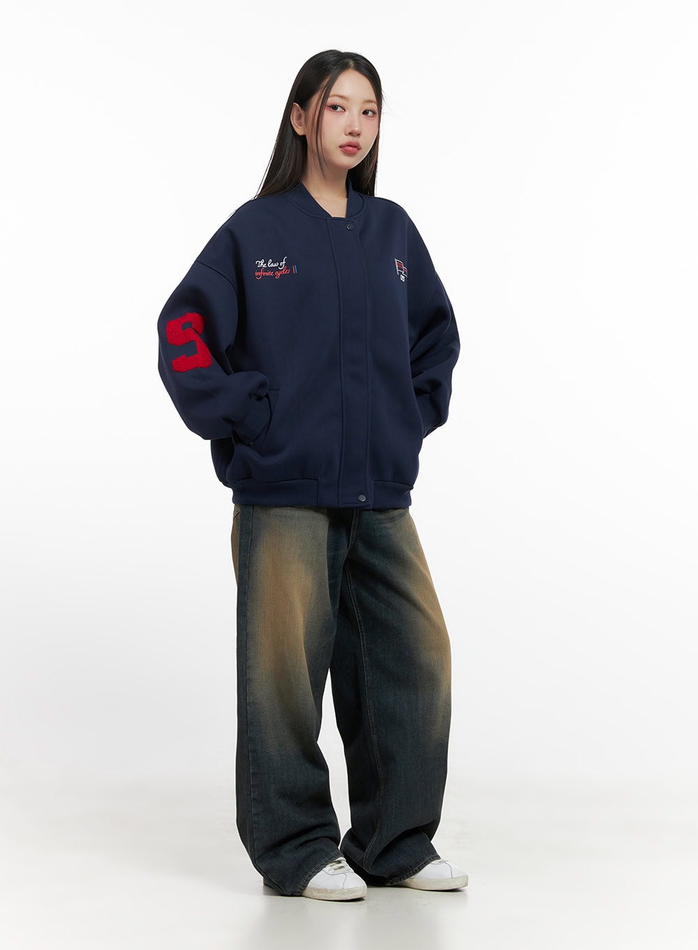 Bryana Cotton Comfort Wide Leg Jeans CN419 in dark blue, full-body front shot on model, vintage amber-wash wide leg denim paired with navy varsity bomber jacket and white sneakers, street acubi look.