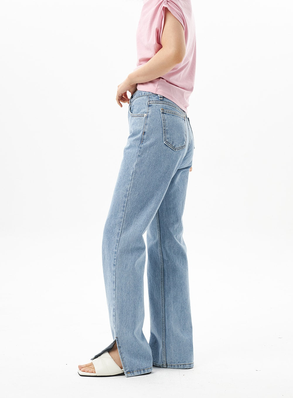 Slit Detail Jeans OU314 in blue, side view on model showing hem slit detail, straight-leg silhouette with back pocket visible, styled with pink top and white sandals.