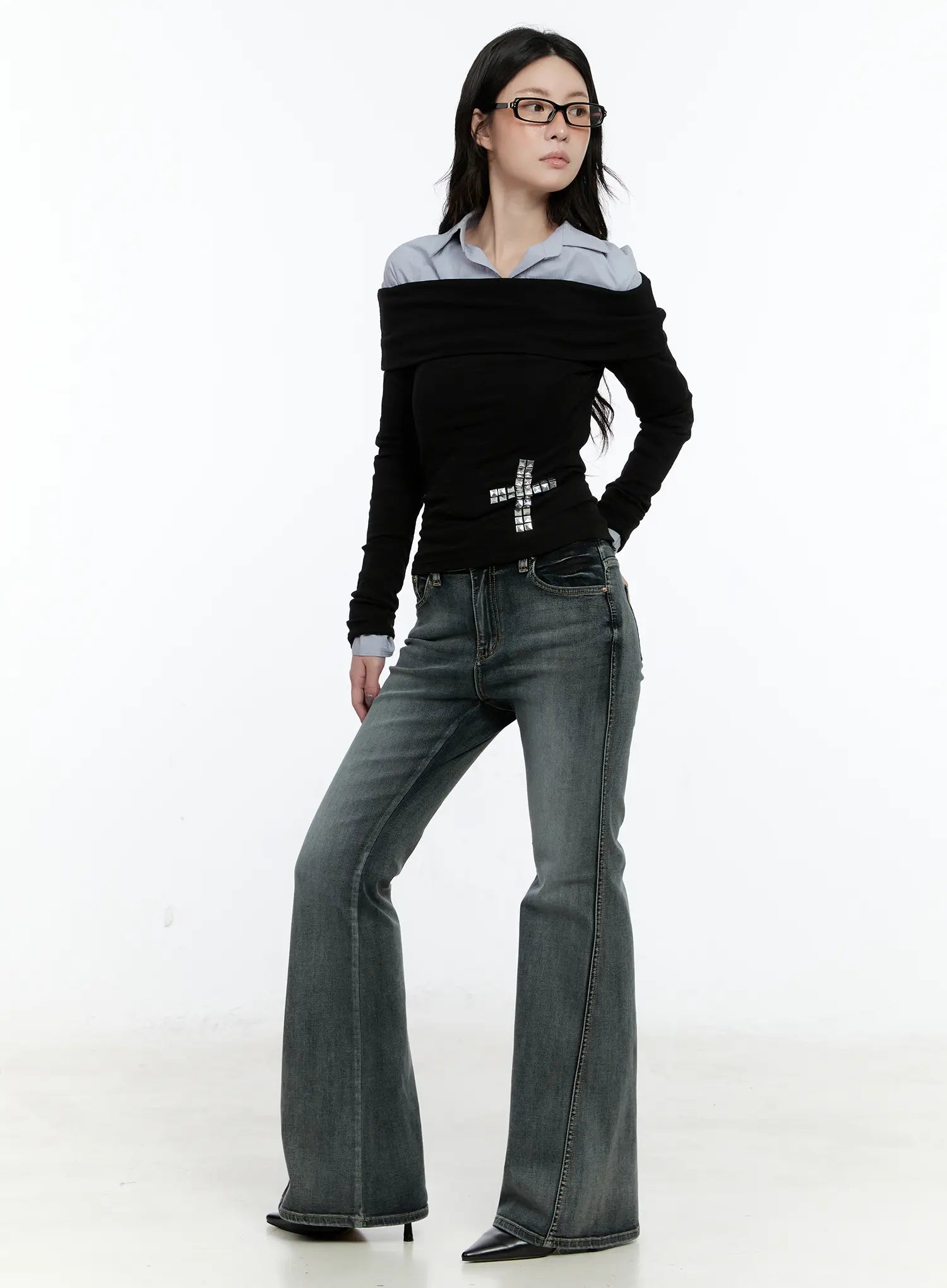 Judith Washed Bootcut Jeans CN517 in blue, full-length front shot on model wearing glasses, bootcut flare silhouette styled with black off-shoulder knit top and black heels.