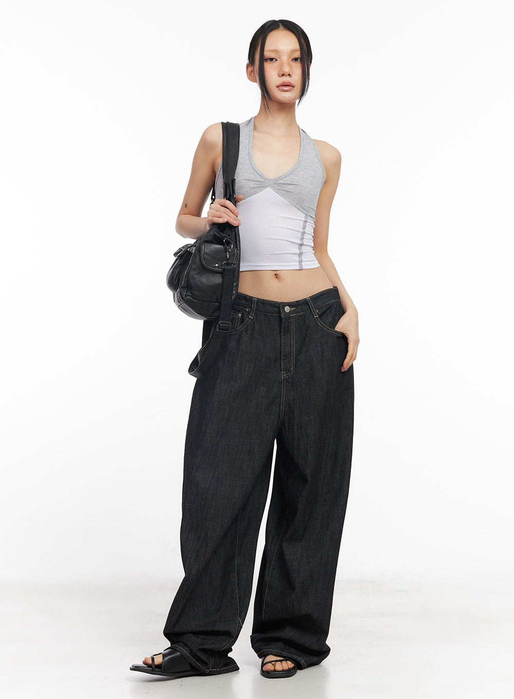 Elvie Baggy Jeans CY528 in black, full-length front shot on model, oversized wide-fit denim styled with a crop halter top and black leather bag.