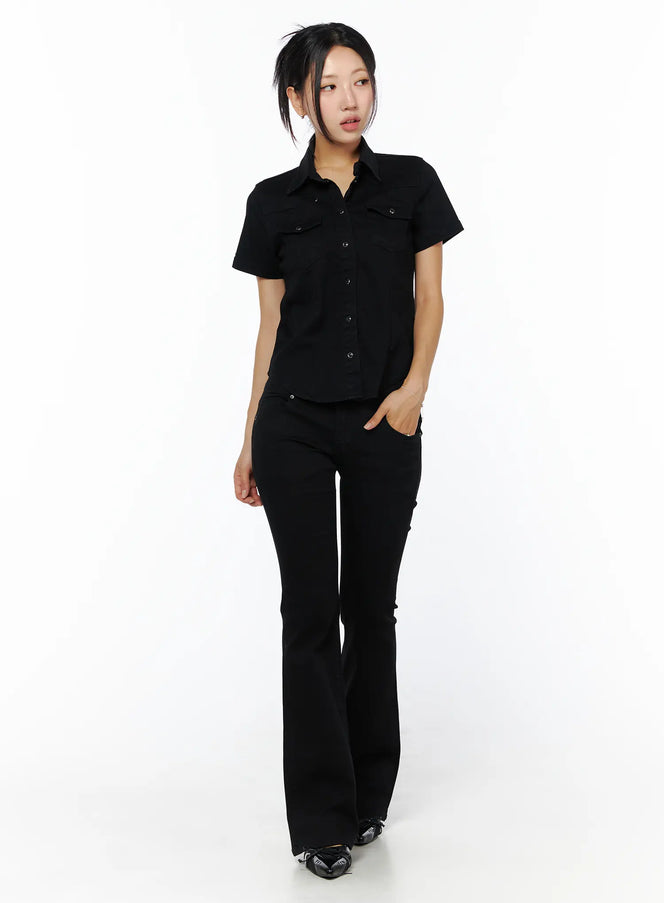 Slim Fit Short Sleeve Button-Up CU512 in black, full-body front view on model, slim-fit cotton-spandex button-up with collar and dual chest pockets, styled with black flare pants.