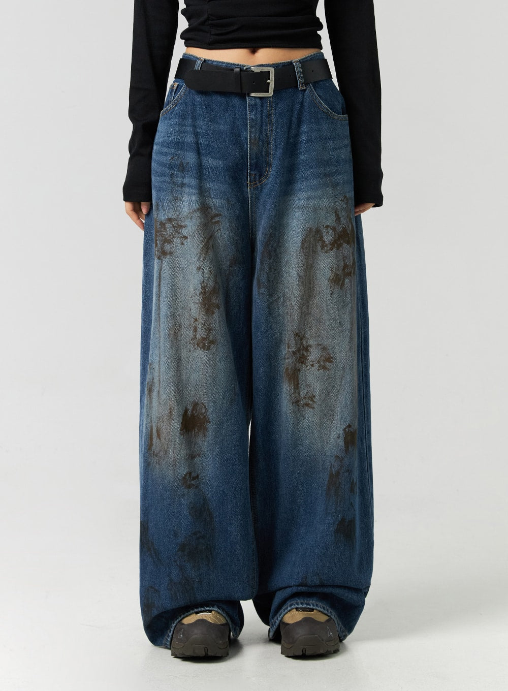 Street-Style Wide Fit Washed Jeans CO323 in Blue, front waist-to-hem close-up on model, wide leg silhouette with bold brown distressed wash pattern and black square-buckle belt.