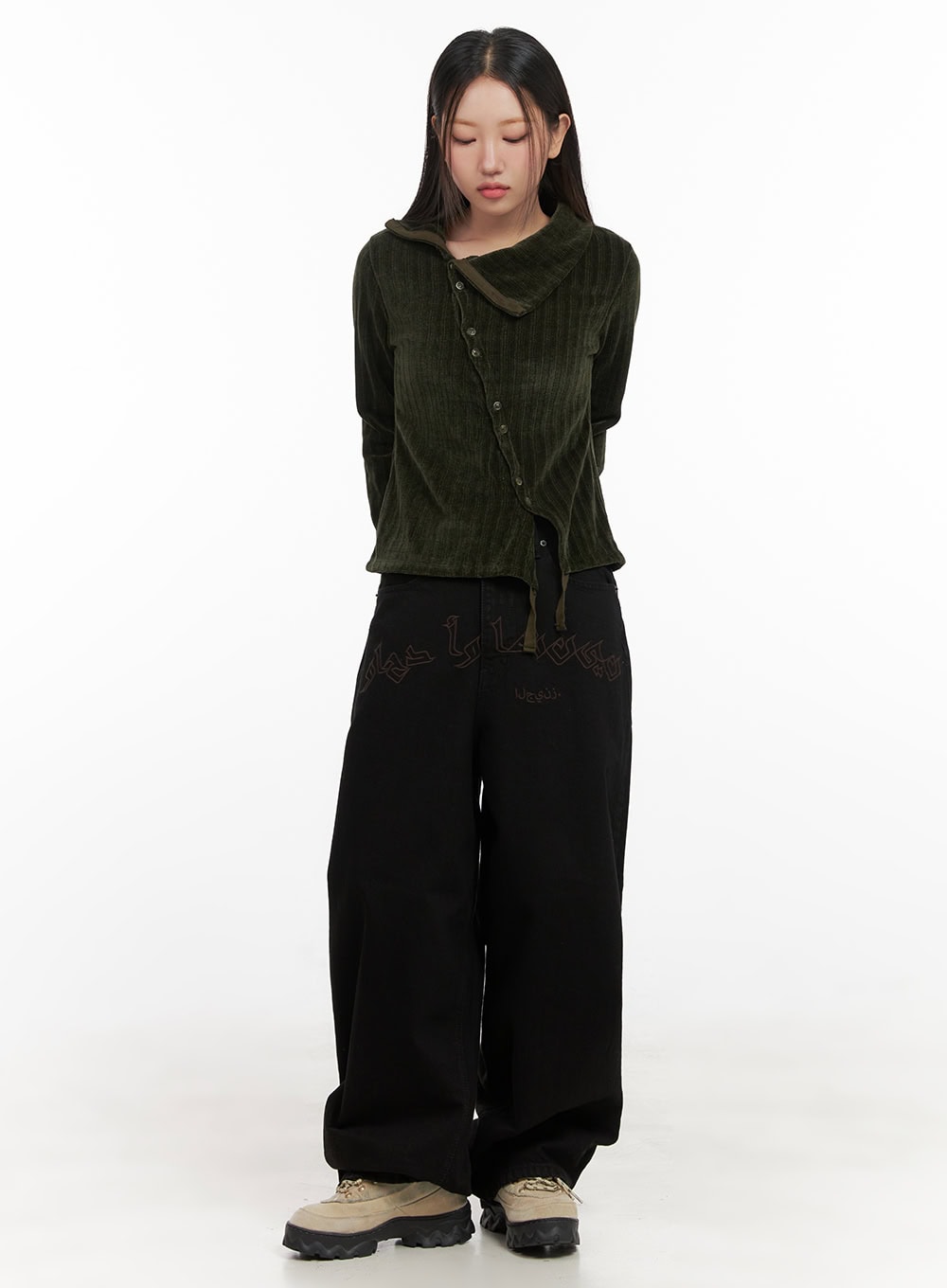 Yasmin Denim Wide Fit Jeans CD413 in black, full-length front shot on model standing, extra-wide leg silhouette with Arabic-style lettering, styled with olive hooded ribbed cardigan and tan platform shoes.